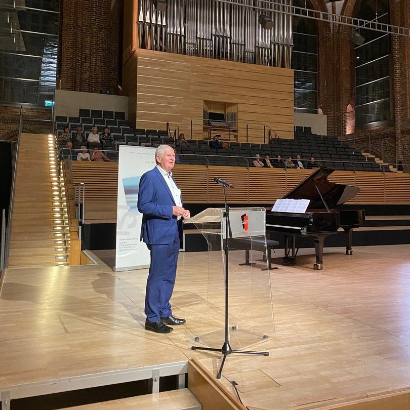 Eine männliche Person steht an einem Rednerpult 